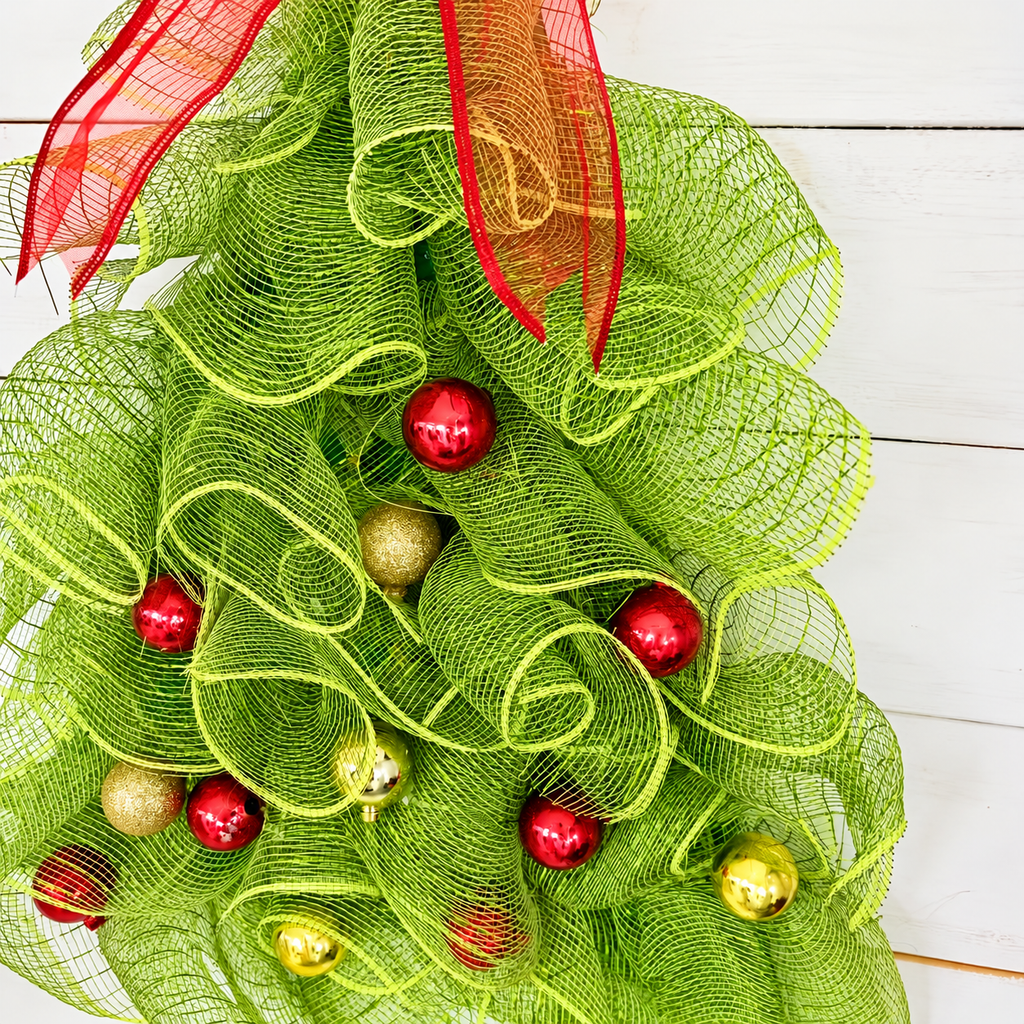 Close up of green mesh loops red bow and red and gold baubles