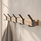 Five-hook black coat rack with natural wood rail and neutral garments.