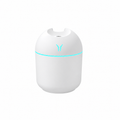 White rounded humidifier with a pale aqua light ring on a white background