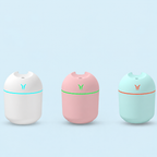 White, pink and blue humidifier finishes with colored light rings against a pale blue background