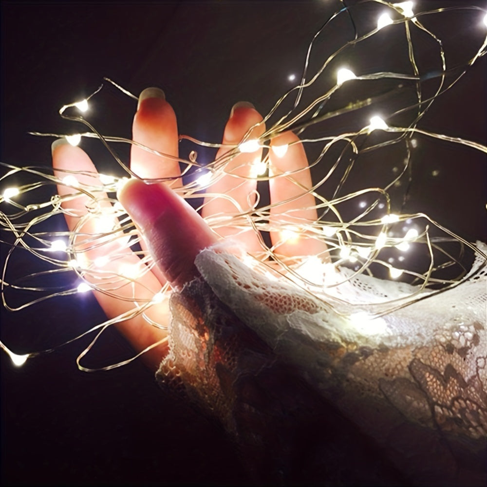 Copper fairy lights glow across a pair of hands.