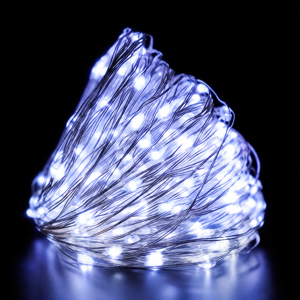 White copper wire fairy lights illuminated in a close-up coil.
