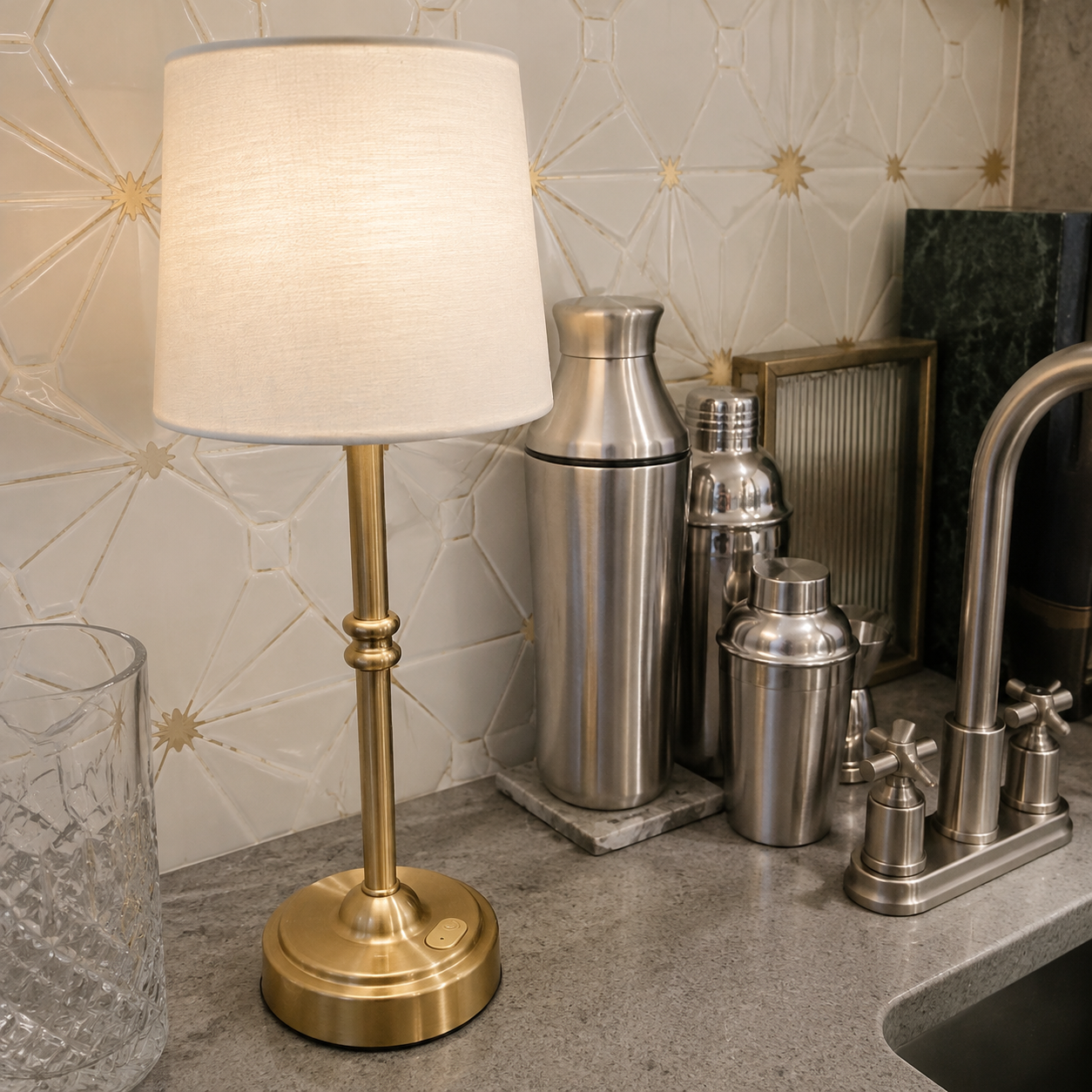 Gold cordless table lamp with cocktail shakers beside an art deco bar sink