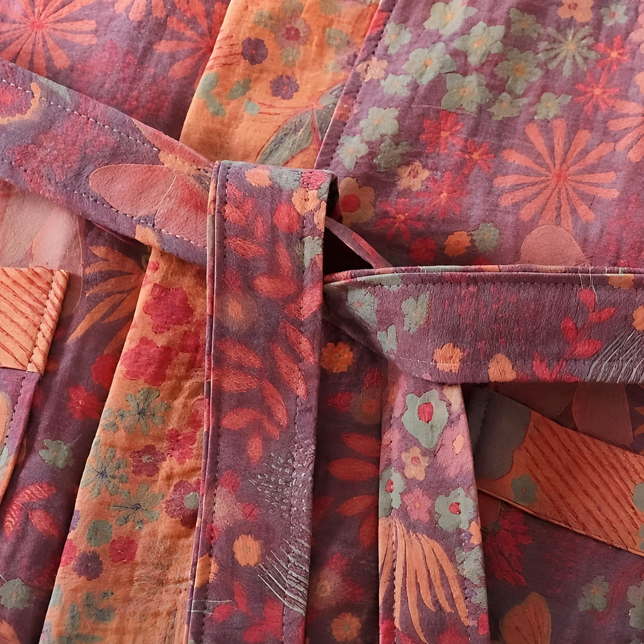 Close view of pink vintage floral double gauze cotton robe fabric and stitching.