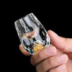 Faceted crystal drinking glass with a rounded profile and gold fleck detail at the base