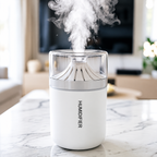 White cup humidifier releasing mist on a marble tabletop