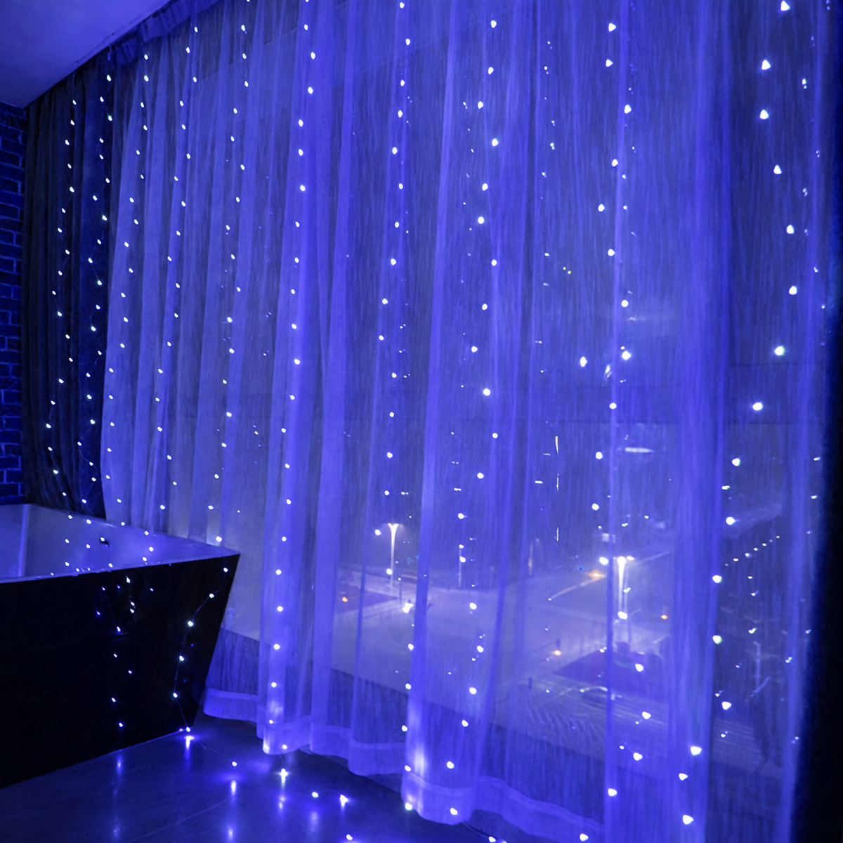 Blue curtain fairy lights glowing across sheer window curtains.