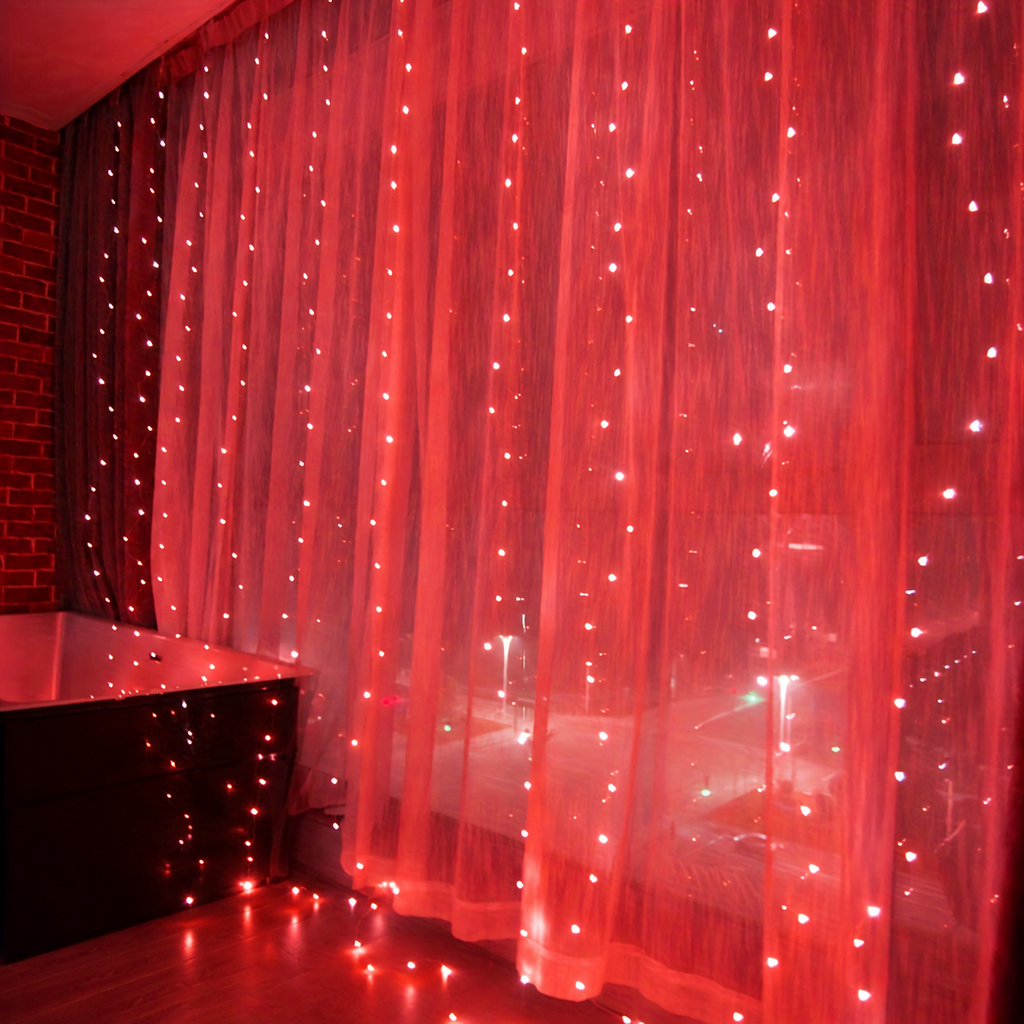 Red curtain fairy lights glowing across sheer window curtains.