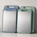 Double sided cutting board with stainless steel and green PP surfaces.