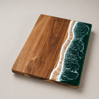 Green resin cutting board shown at an angle on a pale studio surface.