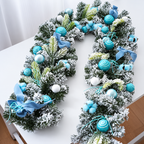 Blue decorated Christmas garland with snowy greenery baubles and ribbon details on a table