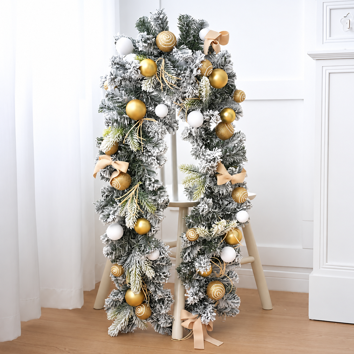 Gold decorated Christmas garland with bows and baubles displayed on a stand