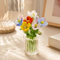 Miniature decorative glass flowers in a vase, mixed blooms