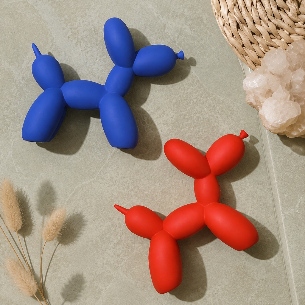 Balloon dog sculpture pair in blue and red viewed from above on a soft rug