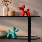 Balloon dog sculpture pair in red and teal styled on black open shelving