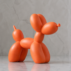 Balloon dog sculpture in glossy orange resin against a pale stone wall