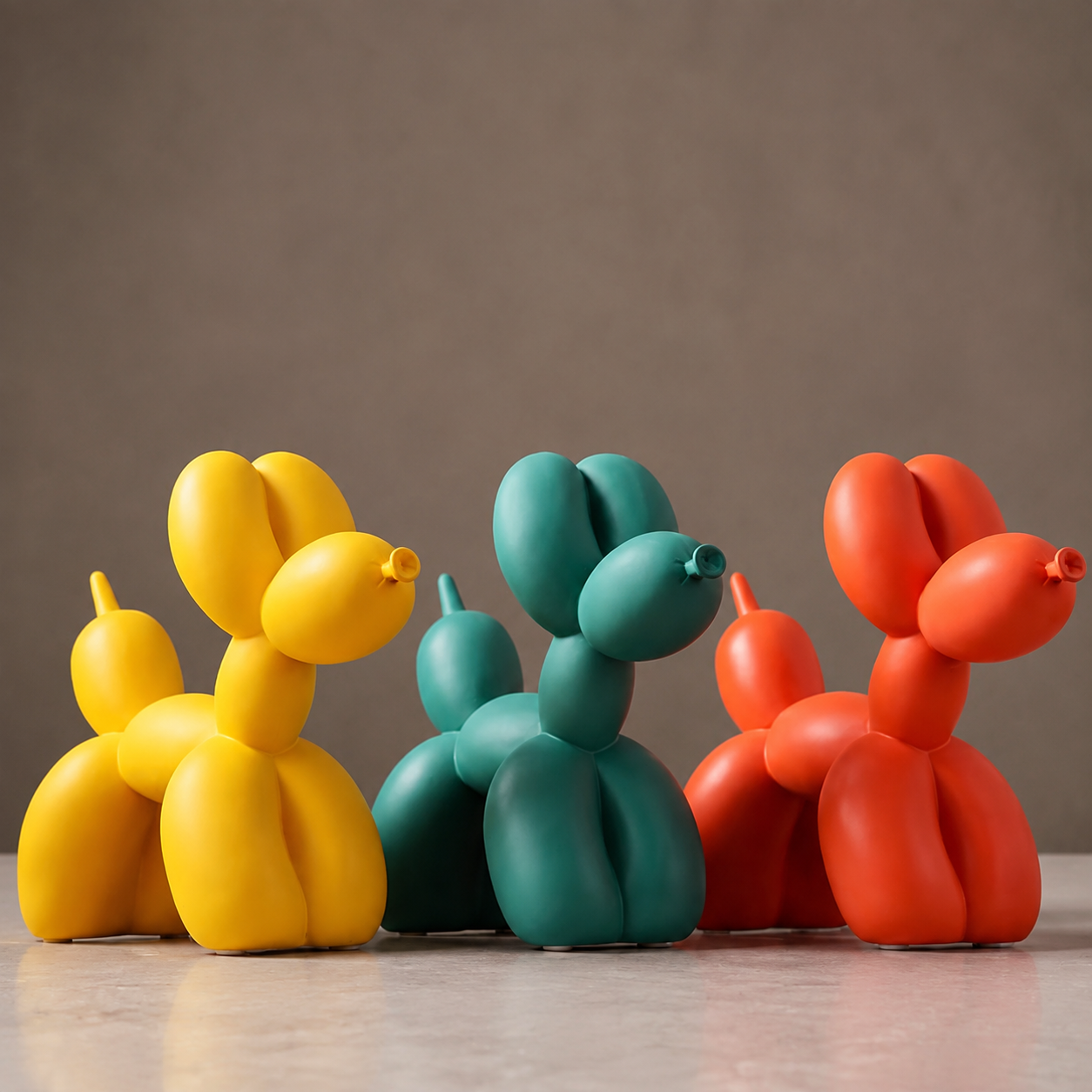 Balloon dog sculpture trio in yellow, teal and orange under warm editorial light