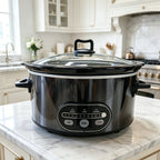 Black digital slow cooker with glass lid on a marble counter