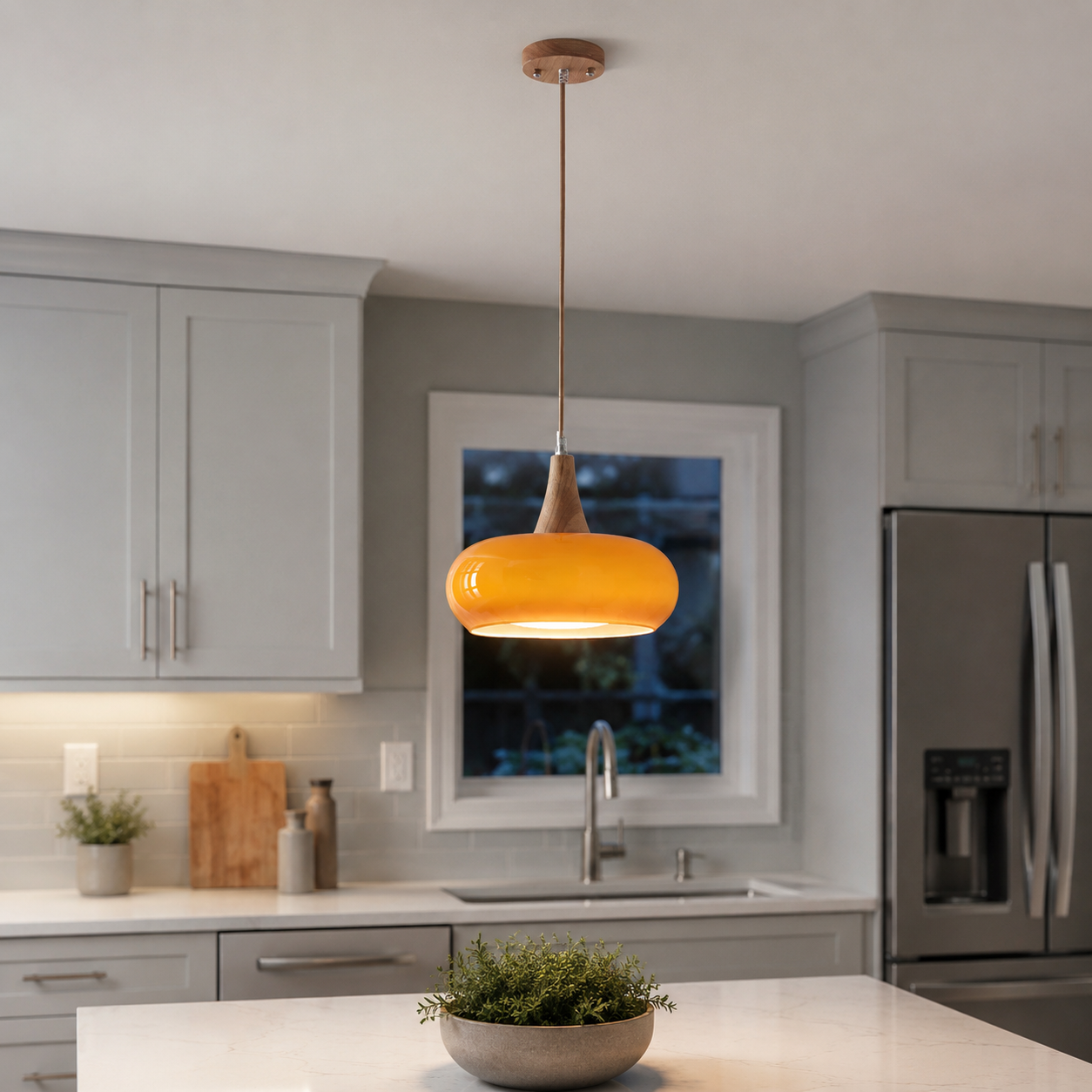 Orange pendant light suspended over a kitchen island with white cabinets and countertops.