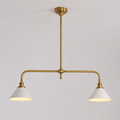 Brass two head pendant light with white cone shades displayed against a plain neutral background.