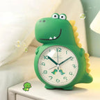 Dinosaur alarm clock in dark green displayed beside a bed with a soft glowing dial.