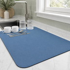 Dish drying mat in blue holding cups and glasses on a marble-look counter