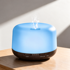 Dome aroma diffuser with blue lighting and a dark wood grain base on a sunlit wooden table