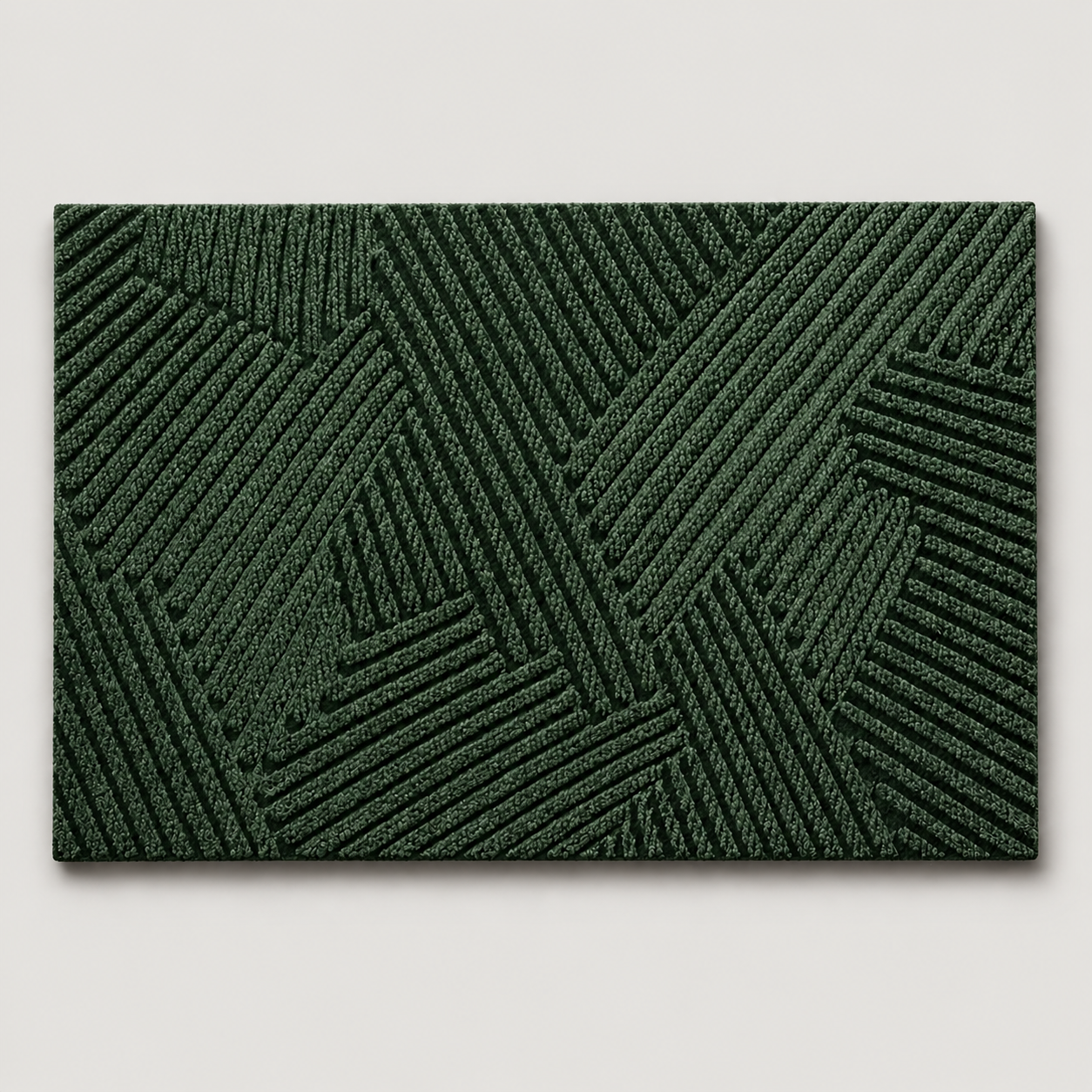 Green geometric door mat shown alone on a soft light gray studio background.
