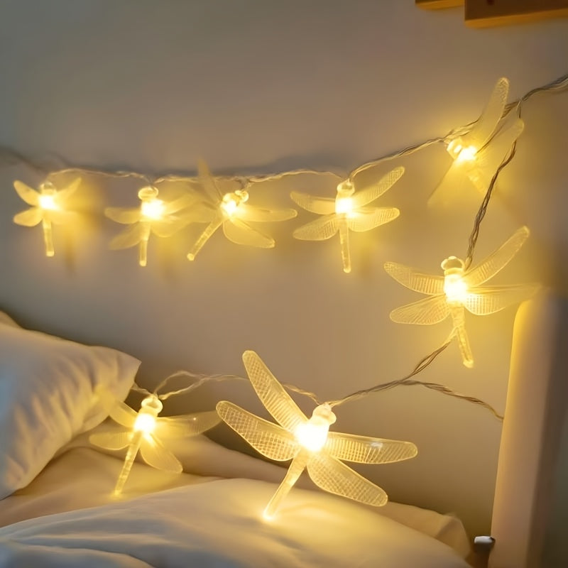 Dragonfly fairy lights hang over a cream sofa cushion.