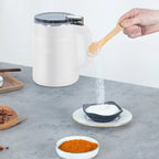 Electric grain mill in white beside a serving dish on a kitchen counter.