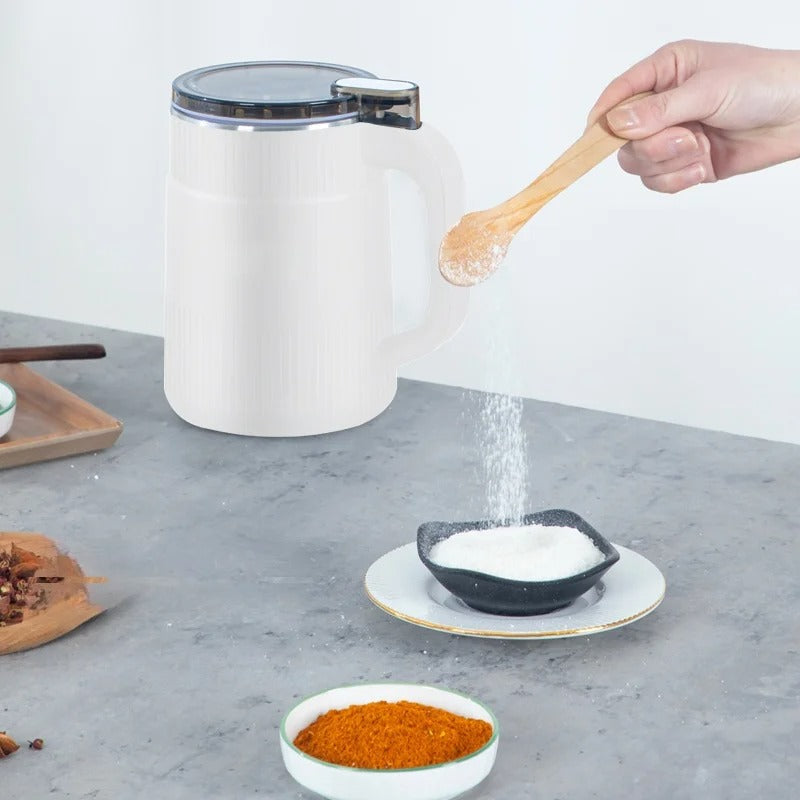 Electric grain mill in white beside a serving dish on a kitchen counter.