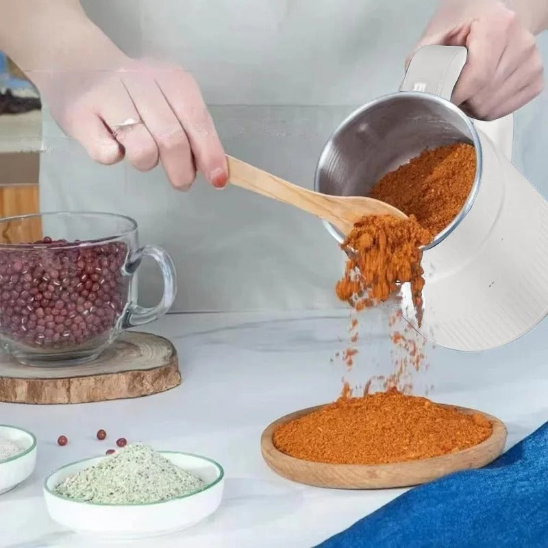 Electric grain mill being used to pour freshly ground ingredients.
