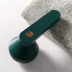 Green fabric shaver resting on folded gray material