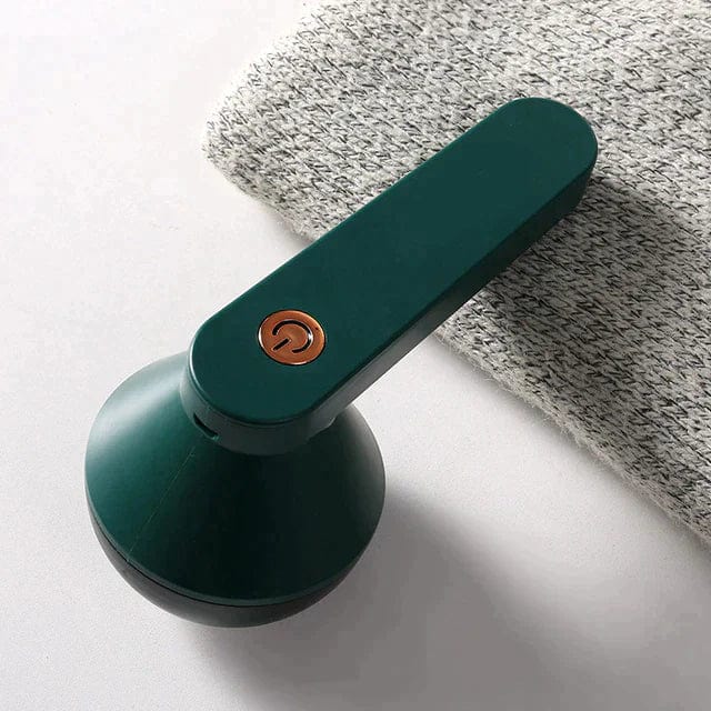 Green fabric shaver resting on folded gray material