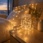Fairy string lights glowing inside a glass jar beside a window.