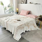 White faux fur throw blanket covering a bed with pink pillows.