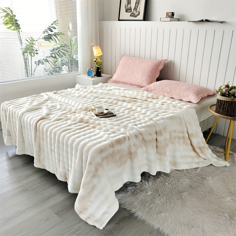 White faux fur throw blanket covering a bed with pink pillows.