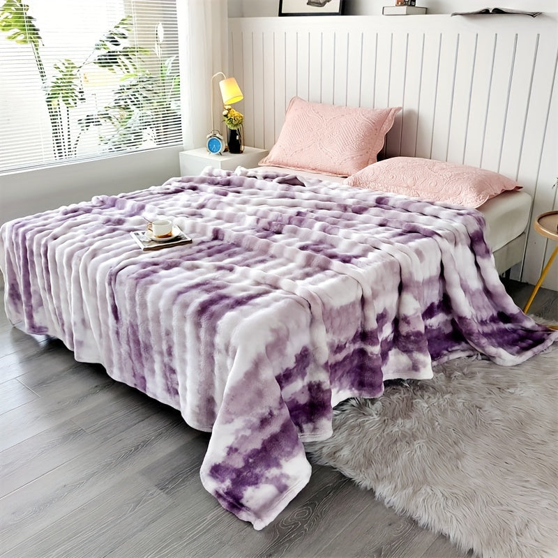 Purple and white faux fur throw blanket spread across a bed.
