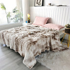 Brown and cream faux fur throw blanket spread across a white bed.