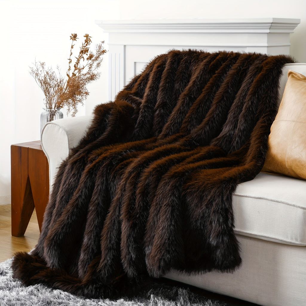Dark brown faux fur throw blanket draped across a white couch.