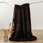 Dark brown faux fur throw blanket hanging from a branch.