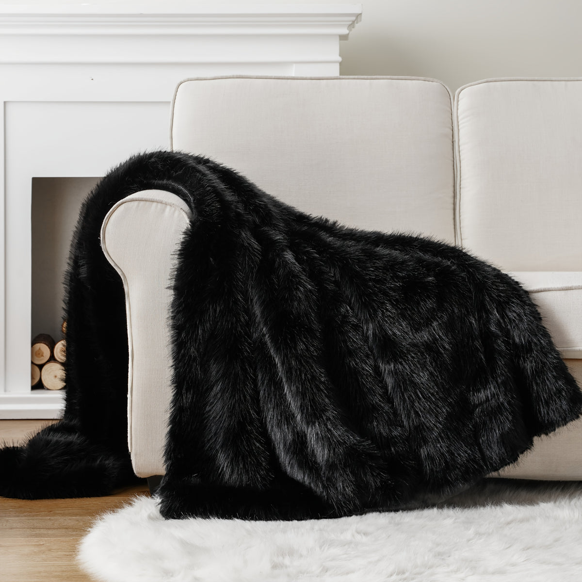 Black faux fur throw blanket draped over a white couch.