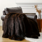 Dark brown faux fur throw blanket draped over a leather armchair.