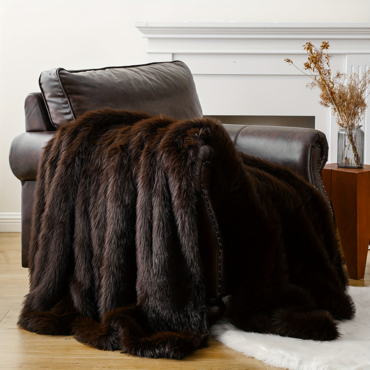 Dark brown faux fur throw blanket draped over a leather armchair.
