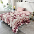 Red and cream faux fur throw blanket spread across a bed.