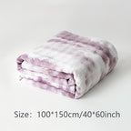 Folded purple faux fur throw blanket with a size label beneath it.