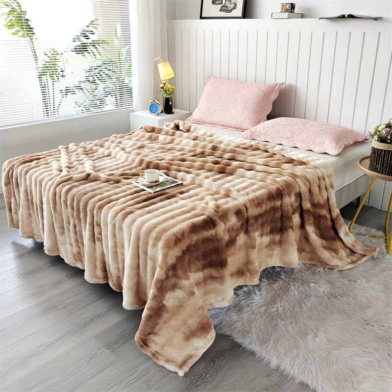 Brown faux fur throw blanket covering a bed with pink pillows.