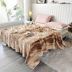 Brown faux fur throw blanket covering a bed with pink pillows.