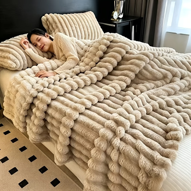 A woman resting under a beige ribbed faux fur throw blanket.