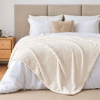 White faux fur throw blanket laid diagonally over white bedding